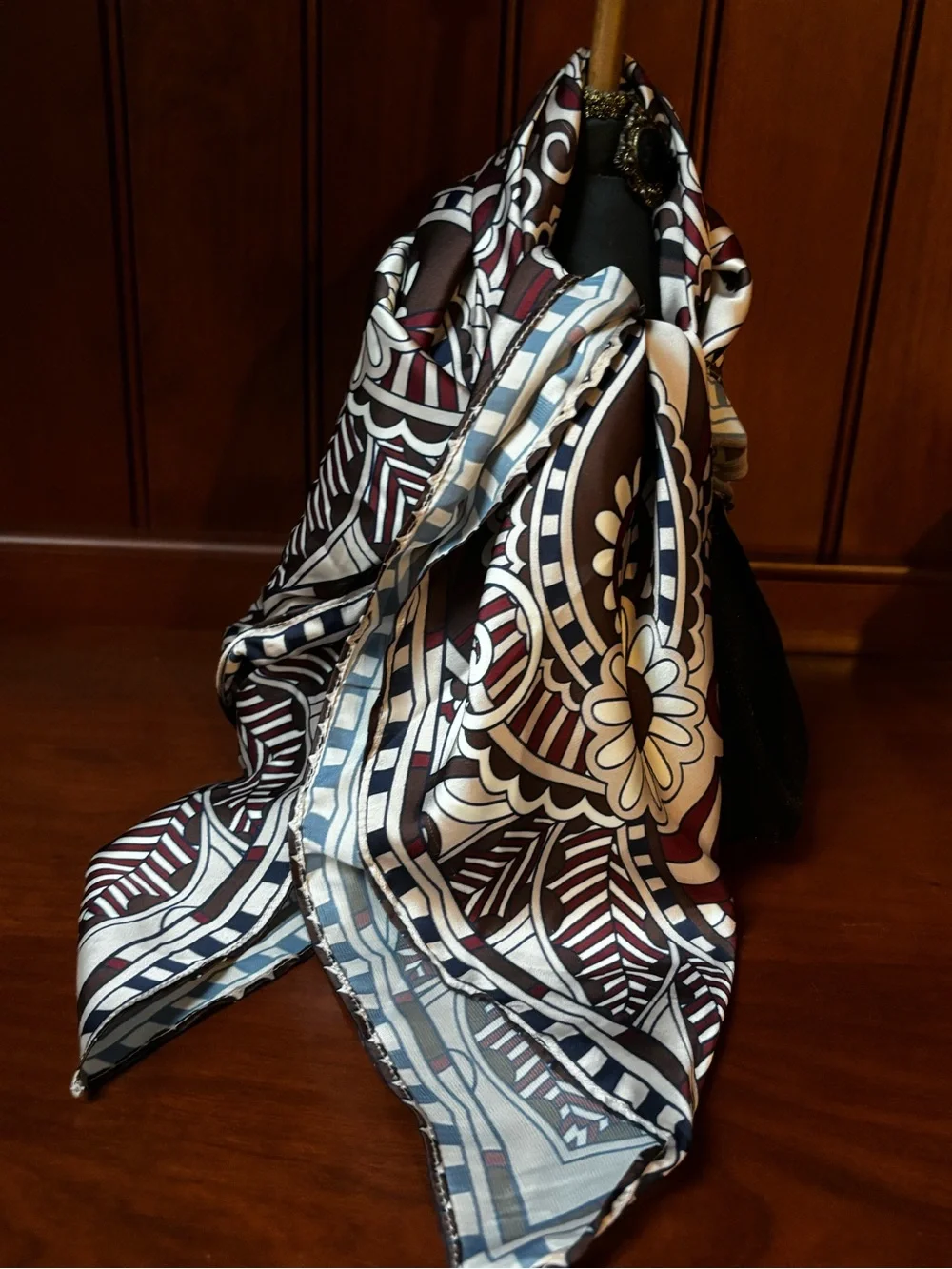 elegant brown, white, and burgundy silk scarf features an ornate floral